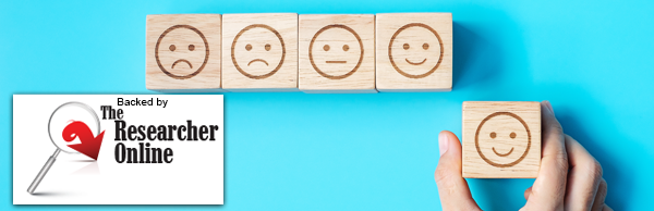 Backed by The Researcher Online. A hand holding wooden block, wooden blocks with emotion faces.